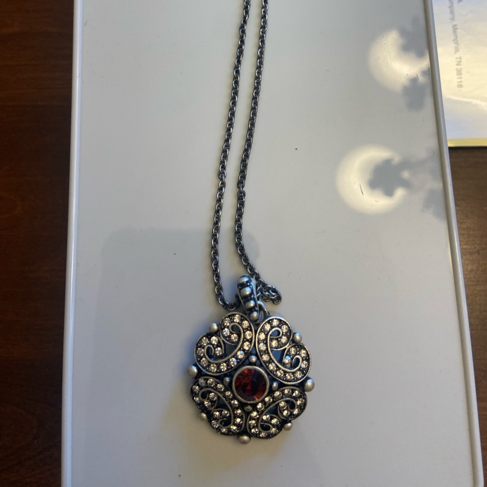 Touchstone Crystal necklace with red crystal in middle.